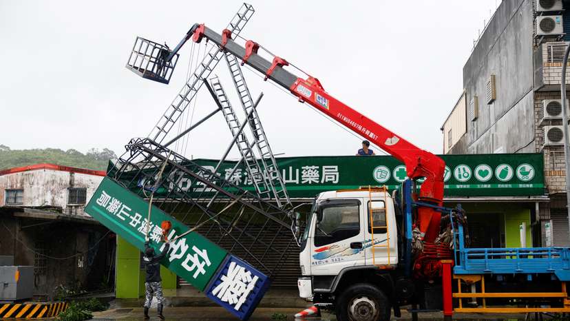 Workers use a crane to remove a fallen sign after Typhoon Gaemi passed northern Taiwan in Yilan