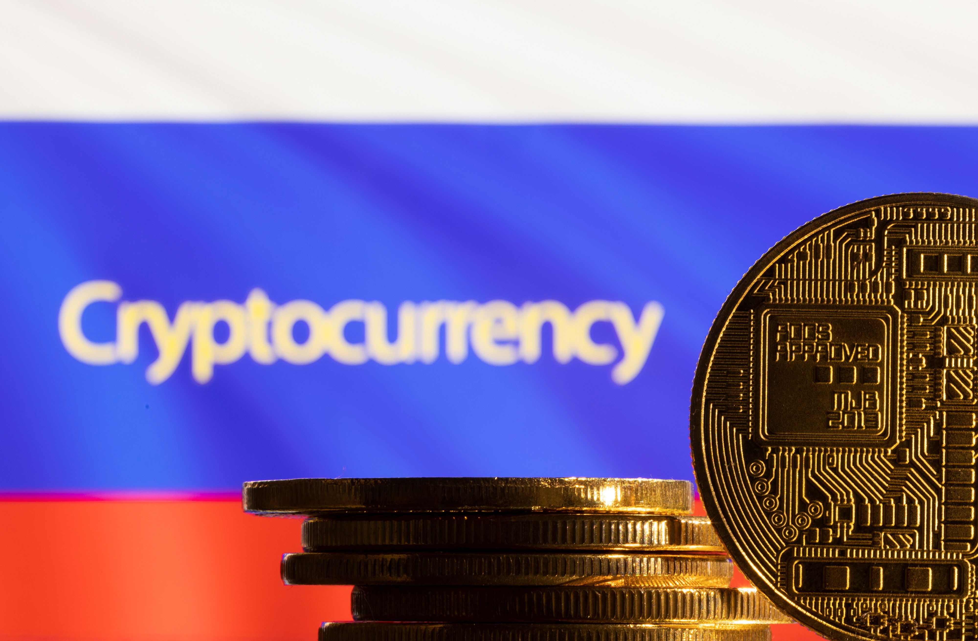 Illustration shows a representation of the cryptocurrency, word "Cryptocurrency" and Russian flag
