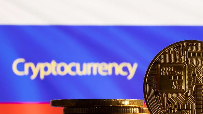 Illustration shows a representation of the cryptocurrency, word "Cryptocurrency" and Russian flag
