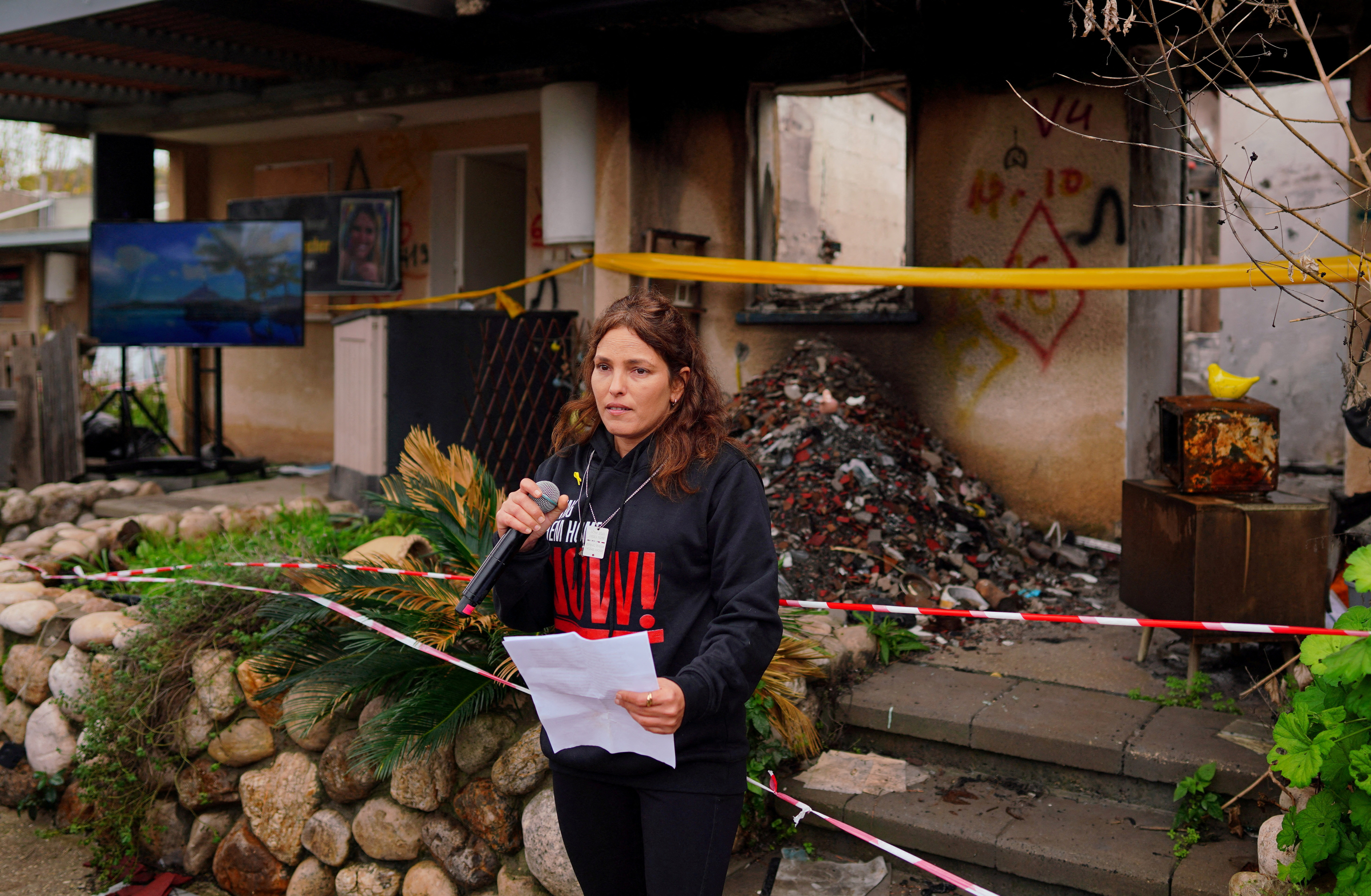 Released hostage Amit Soussana talks to the press in front of her destroyed home at the Kibbutz Kfar Aza