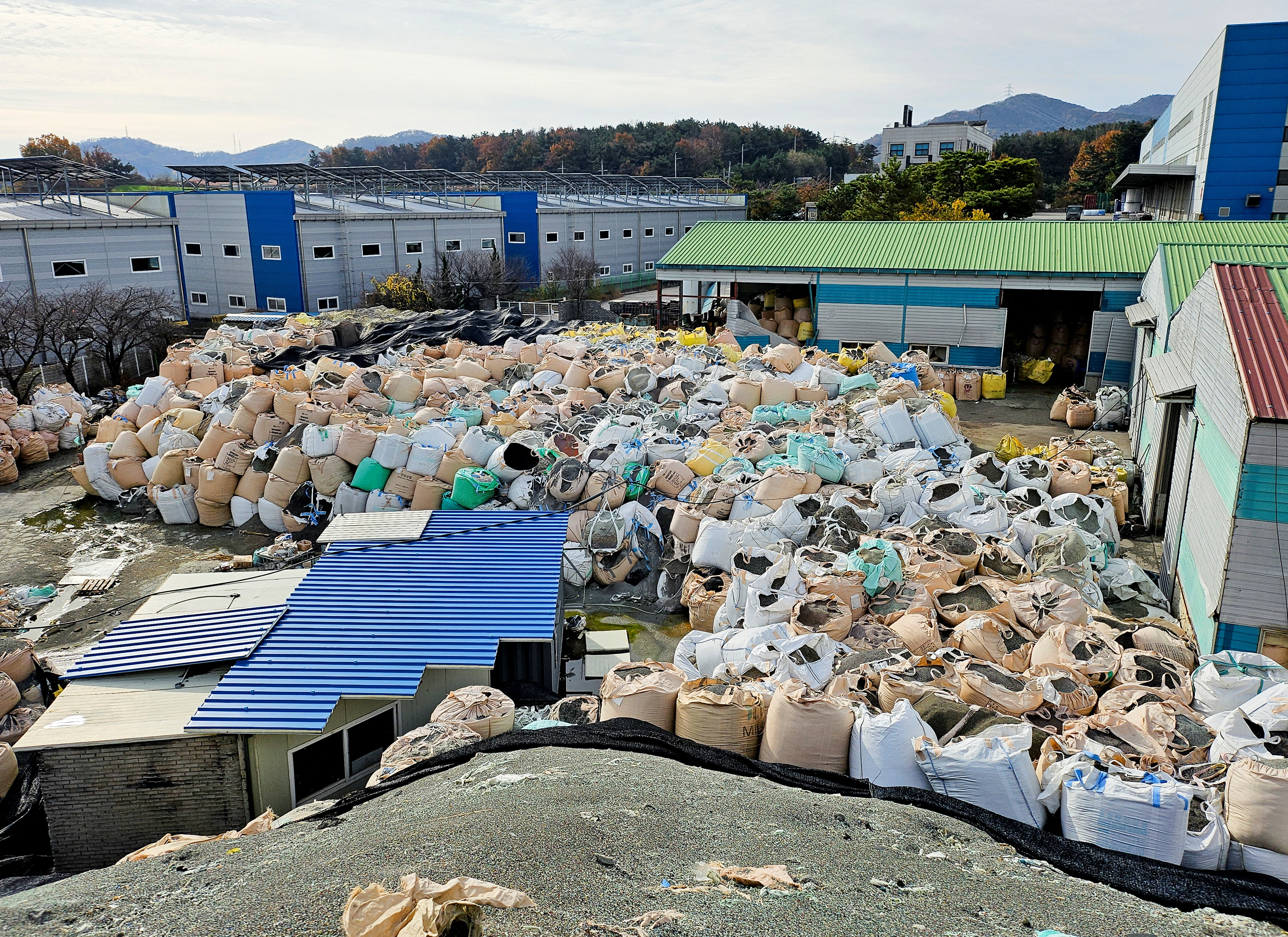A pile of untreated, shredded plastic waste is left unattended at an inoperational recycling site in Asan