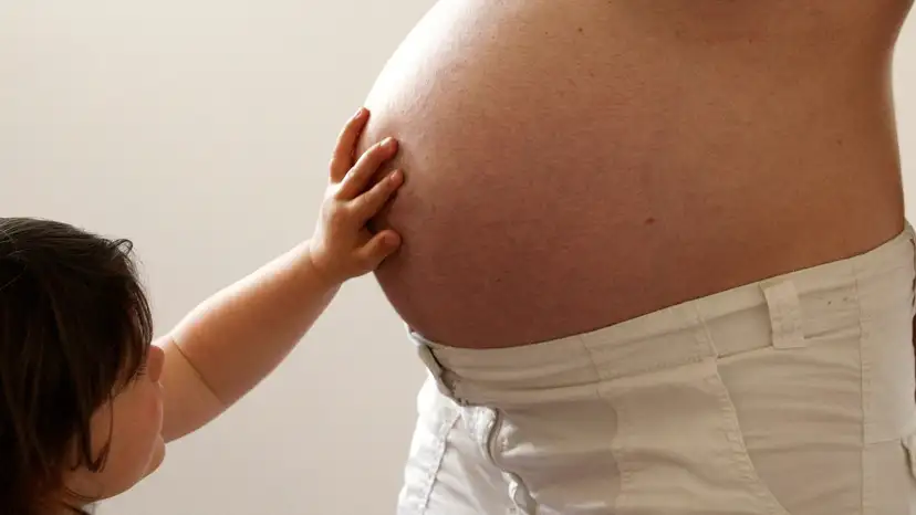 FILE PHOTO: A child touches her pregnant mother's stomach at the last stages of her pregnancy in Bordeaux