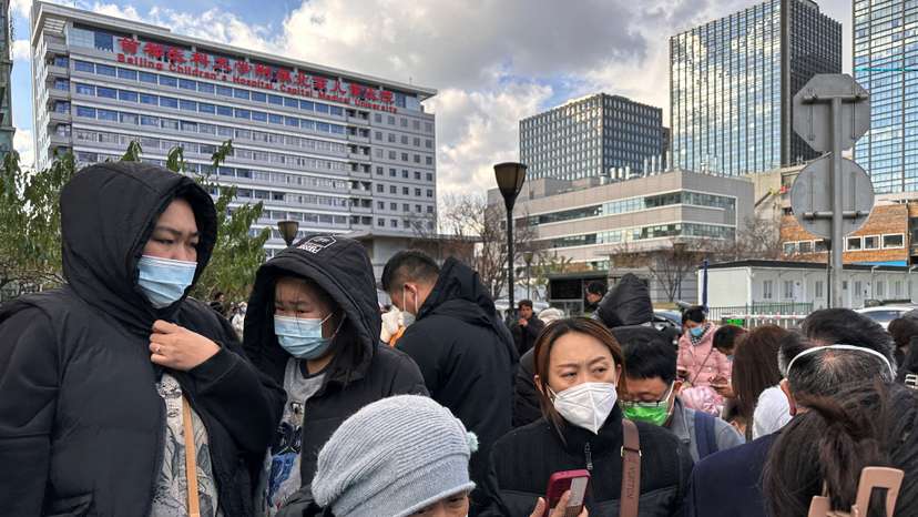 People wait for their rides outside a children's hospital in Beijing