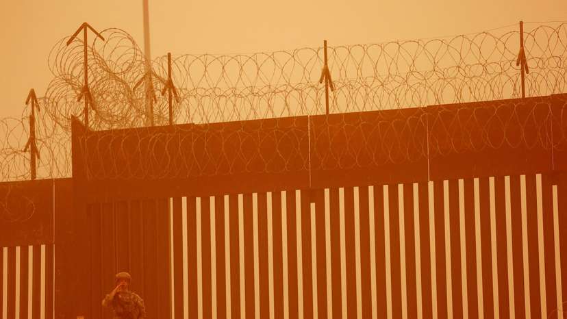 FILE PHOTO: A Texas National Guard soldier stands near the wall on the border between Mexico and U.S. during a sandstorm