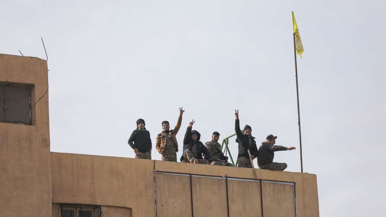 Members of the Kurdish-led Syrian Democratic Forces (SDF) gesture in Deir al-Zor
