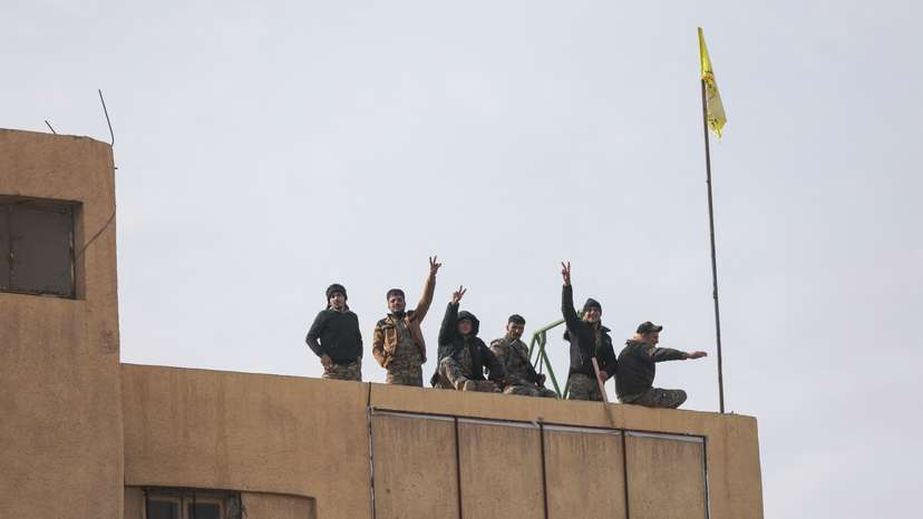 Members of the Kurdish-led Syrian Democratic Forces (SDF) gesture in Deir al-Zor