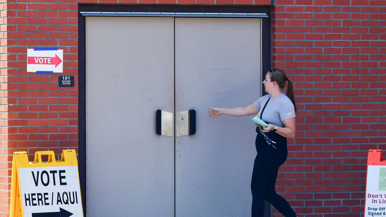 FILE PHOTO: A voter walks into a polling location with her early ballot, in Phoenix