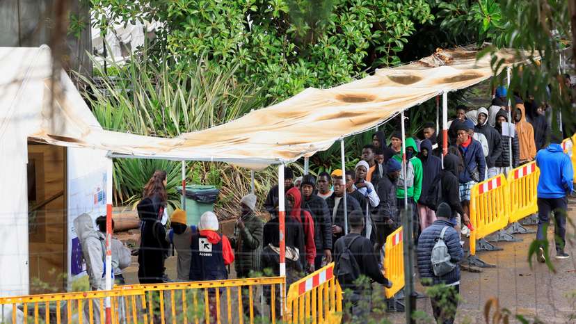 FILE PHOTO: Migrants line up to eat at the Las Raices migrant camp in La Laguna
