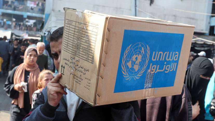 Palestinians receive aid from UNRWA in Deir Al-Balah, central Gaza Strip