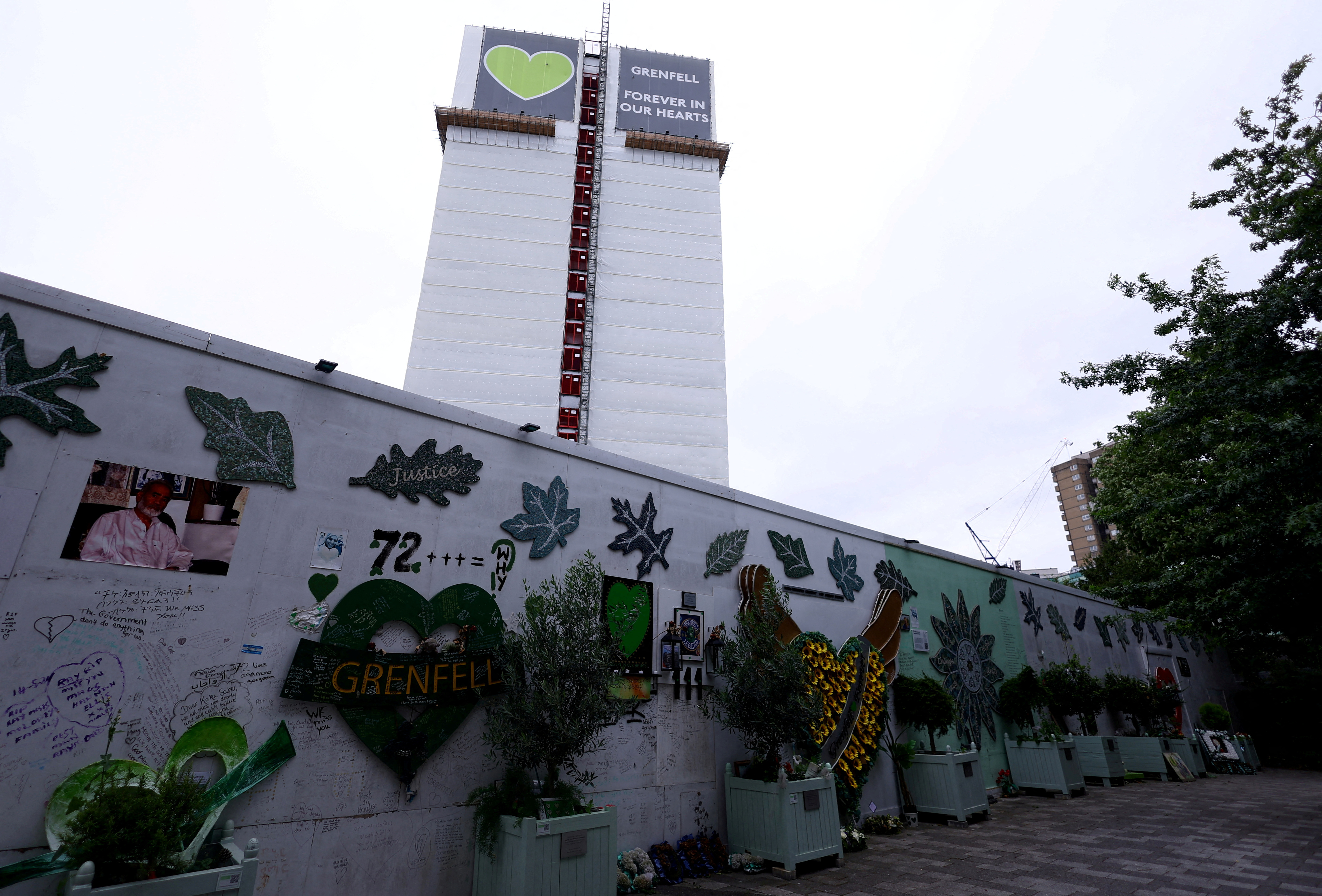 FILE PHOTO: Covered remains of Grenfell Tower seen behind a wall of condolences