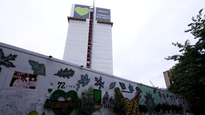 FILE PHOTO: Covered remains of Grenfell Tower seen behind a wall of condolences