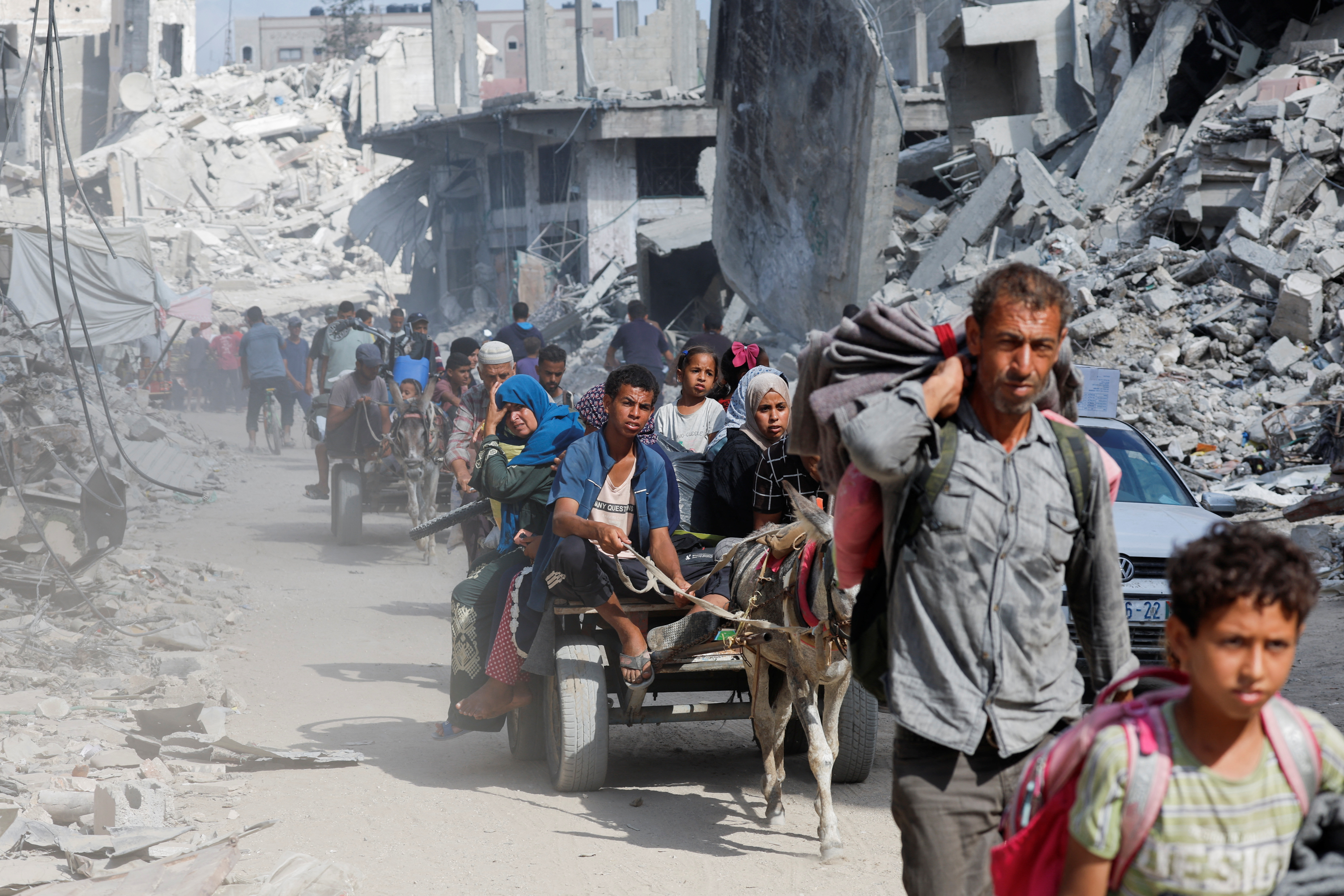 Palestinians make their way to return to neighbourhoods after Israeli forces pulled out from the eastern side of Khan Younis, in Khan Younis, in the southern Gaza Strip