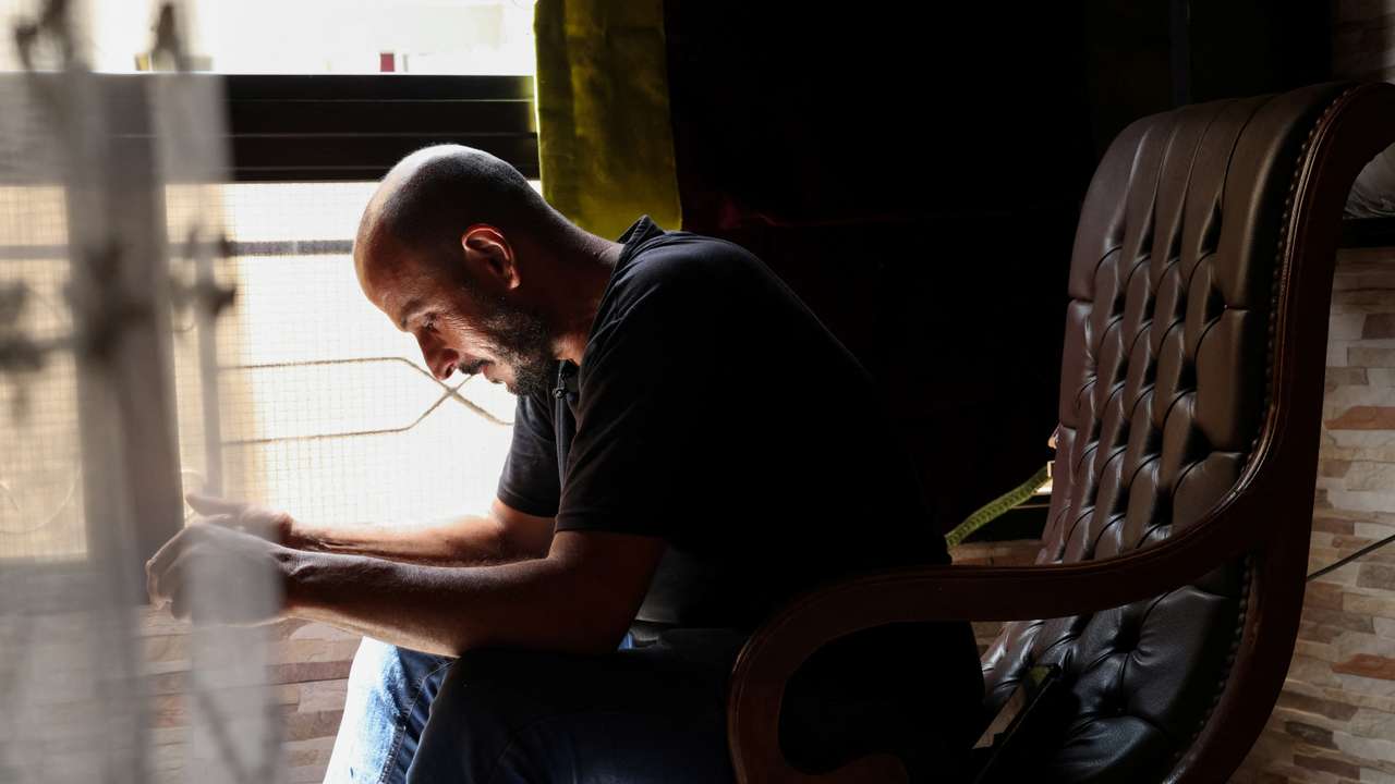 Bilal Sahlab, 45, sits by his window in his home in Dahiyeh