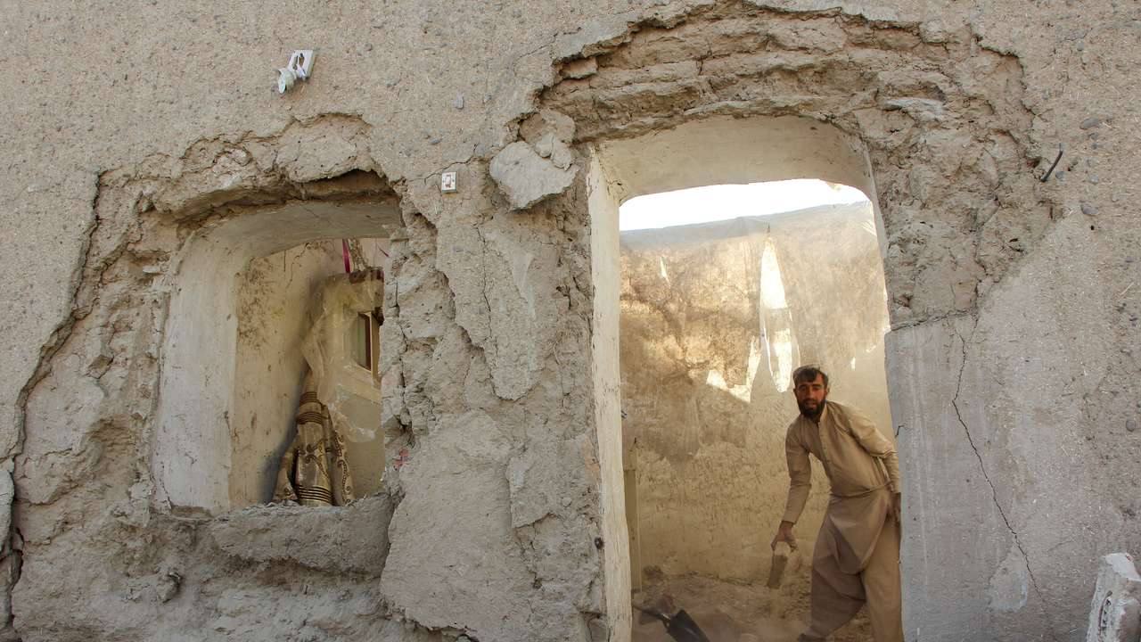 A man clears debris from his house damaged during an airstrike following a temporary ceasefire amid the conflict between Afghanistan and Pakistan, in Spin Boldak