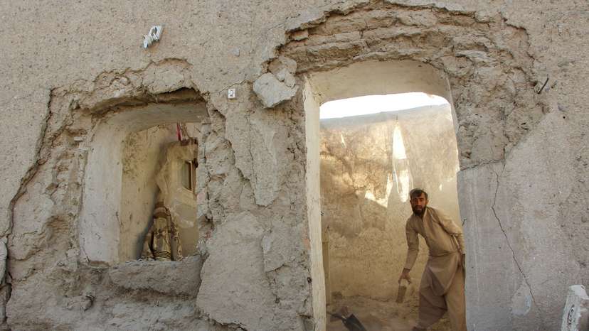 A man clears debris from his house damaged during an airstrike following a temporary ceasefire amid the conflict between Afghanistan and Pakistan, in Spin Boldak