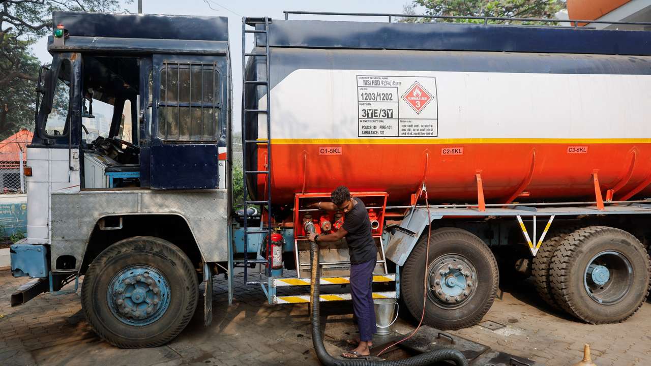 A man opens a valve of a fuel tanker during the refilling of an underground fuel tank, after a petrol pump ran out of fuel after shortages in Mumbai