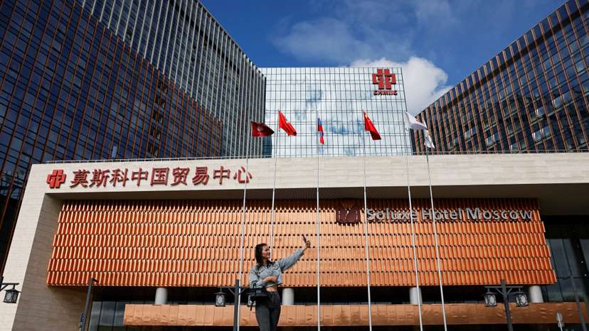 A woman takes a selfie in front of the Soluxe Hotel in a Chinese business centre in Moscow