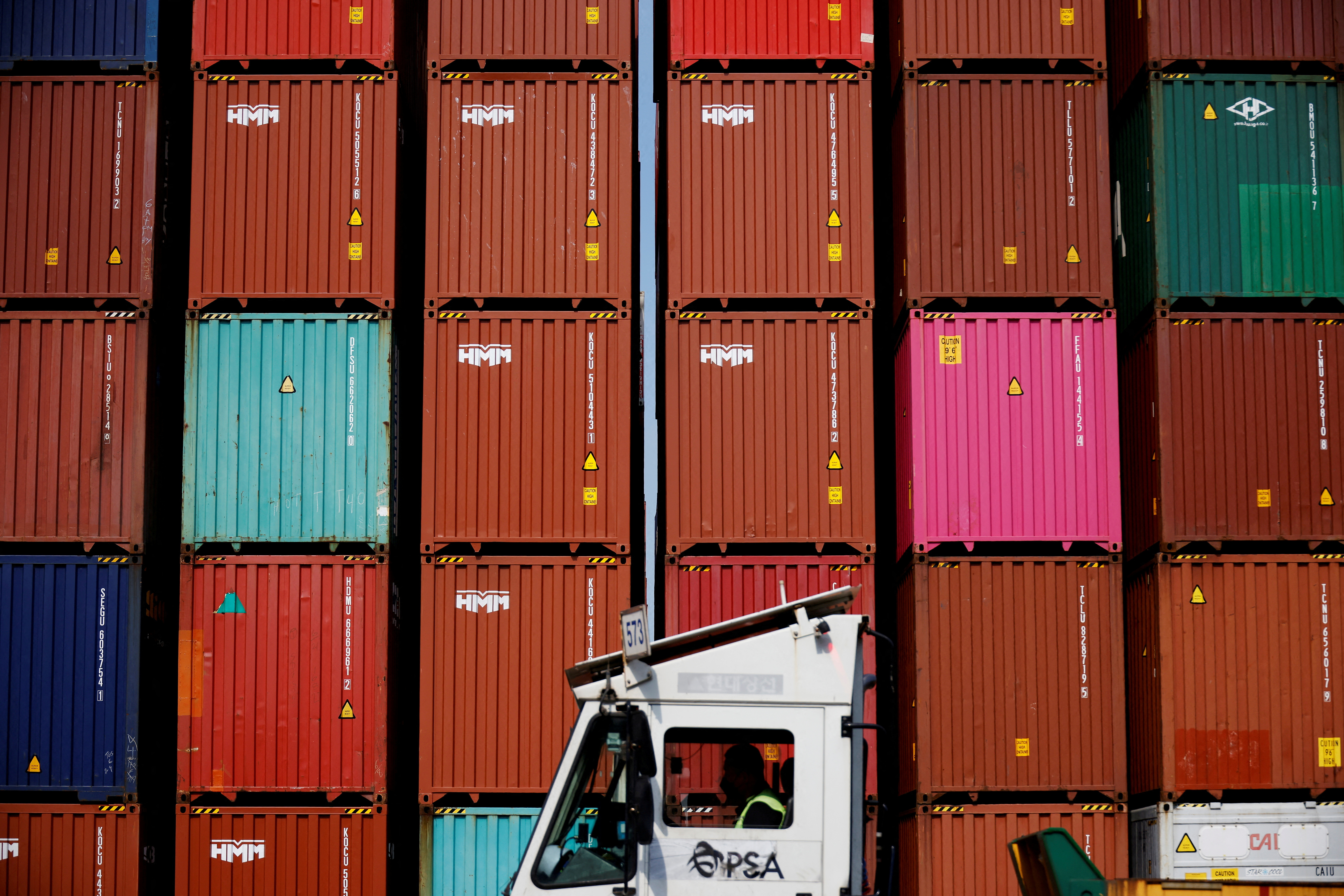 FILE PHOTO: FILE PHOTO: A truck driver works in front of shipping containers stacked up at Pusan Newport Terminal in Busan