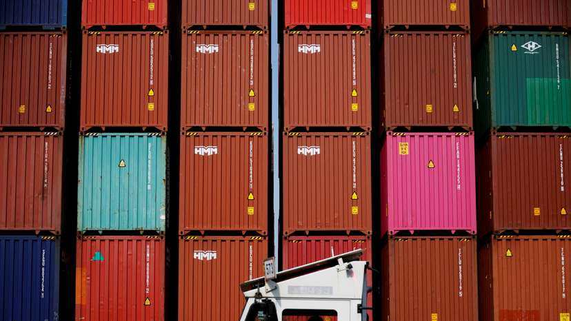 FILE PHOTO: FILE PHOTO: A truck driver works in front of shipping containers stacked up at Pusan Newport Terminal in Busan