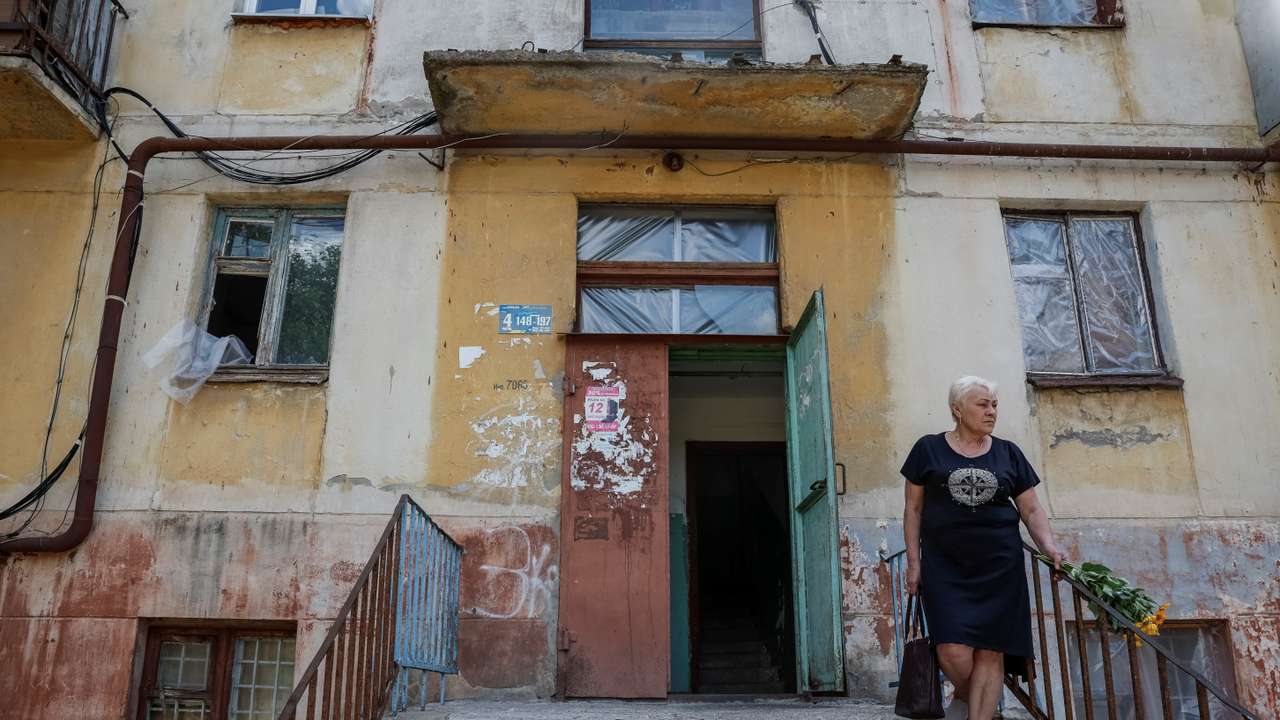 Volunteers of a charitable organisation replace broken by Russian military attacks windows with special frames, in Donetsk region