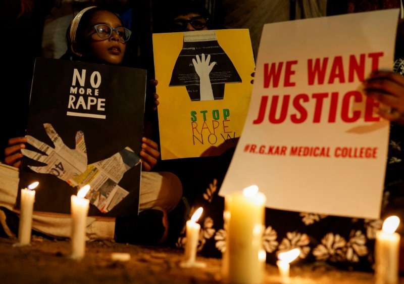People hold posters during a vigil condemning the rape and murder of a trainee medic at a government-run hospital in Kolkata, on a street in Mumbai