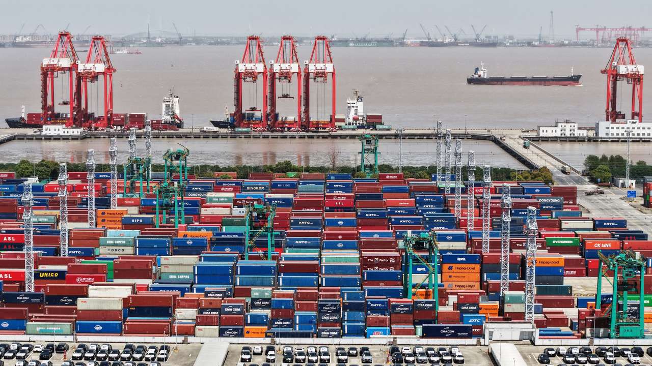 Drone view shows electric vehicles (EV) for export and containers sitting at a port in Shanghai