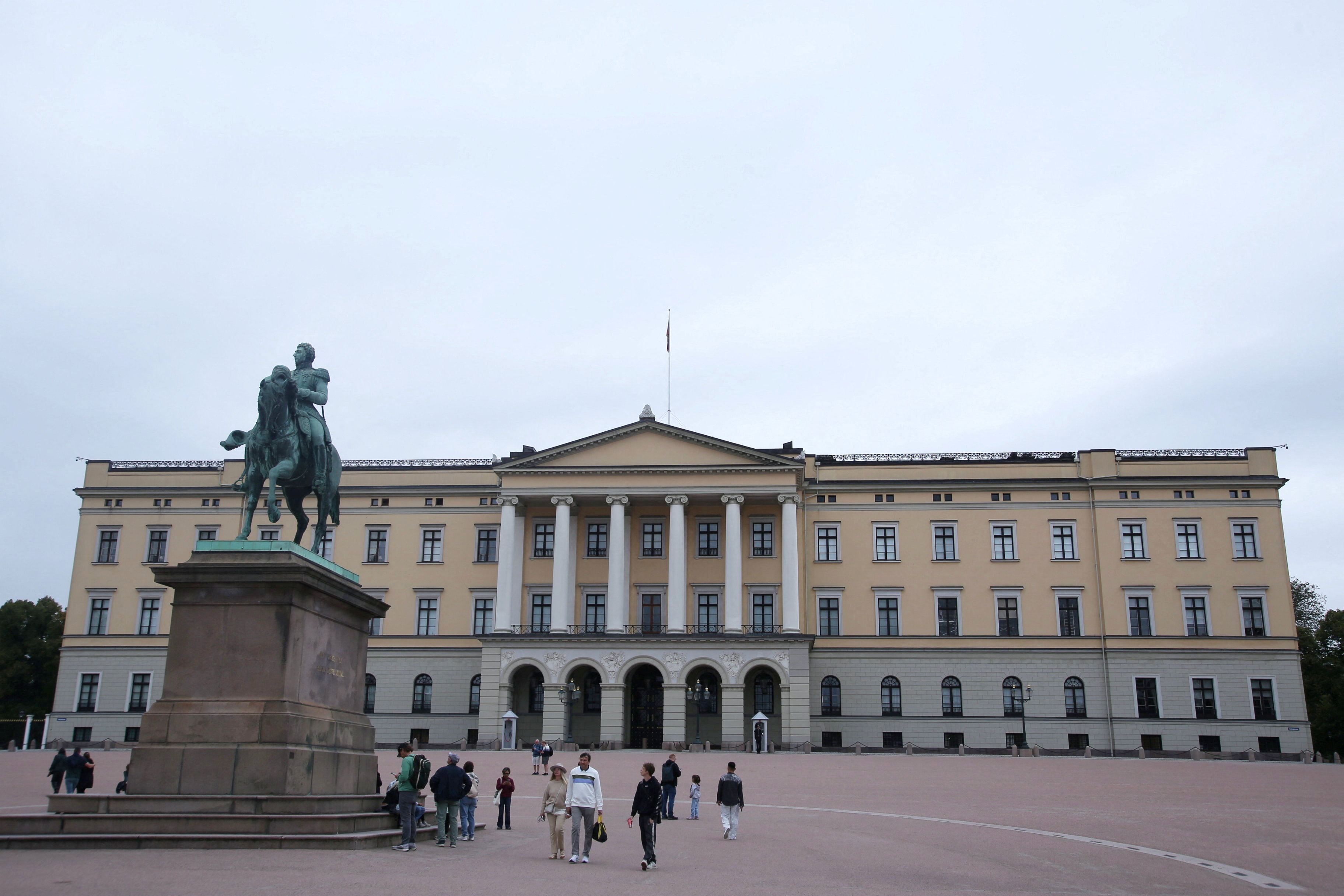 Tourists walk outside the Royal Palace in Oslo