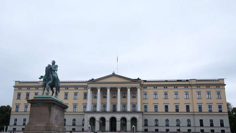 Tourists walk outside the Royal Palace in Oslo