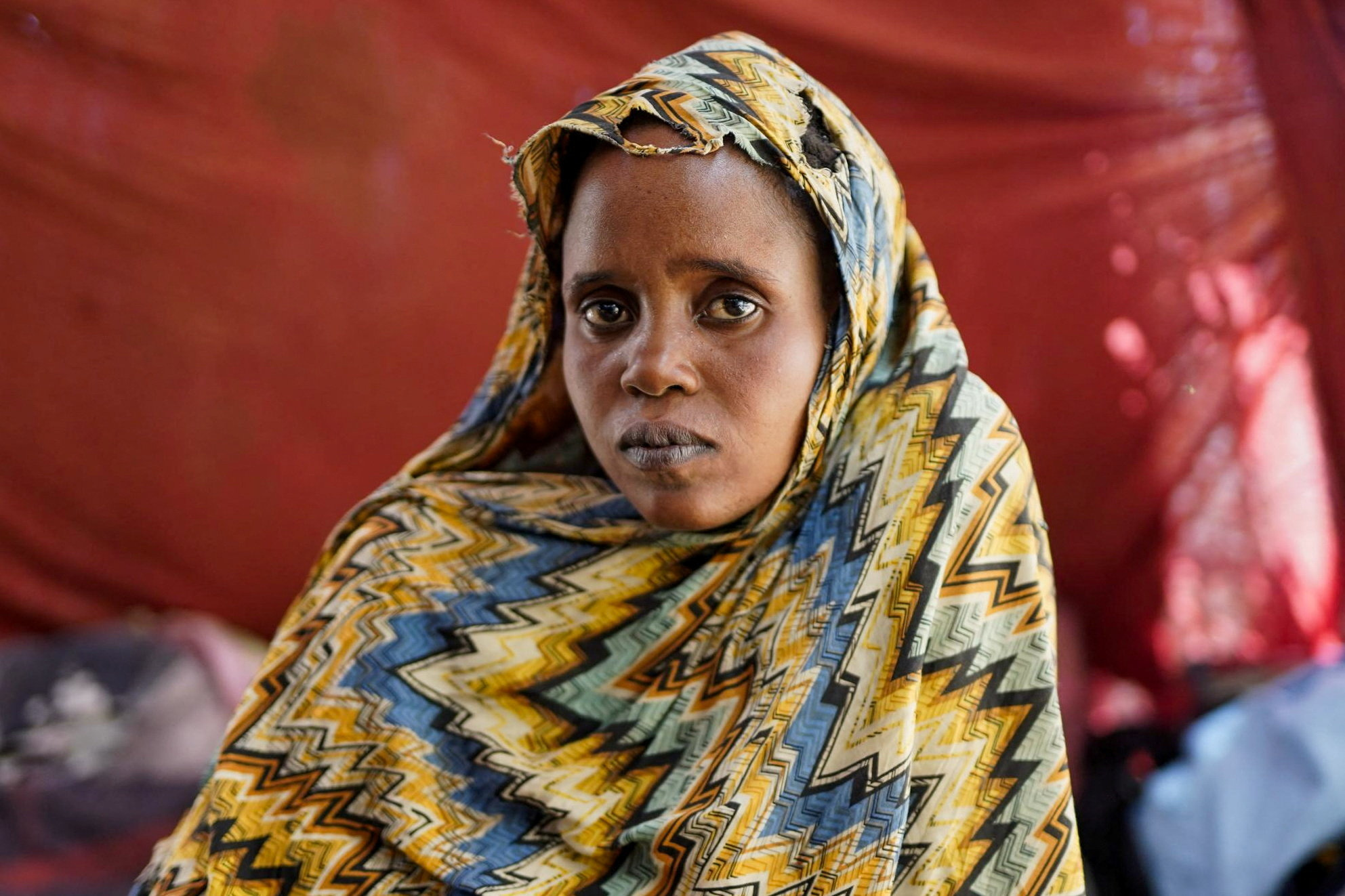 Israa Mukhtar, a witness of the RSF attack on Relief International's medical clinic, stands outside of a tent in Tawila