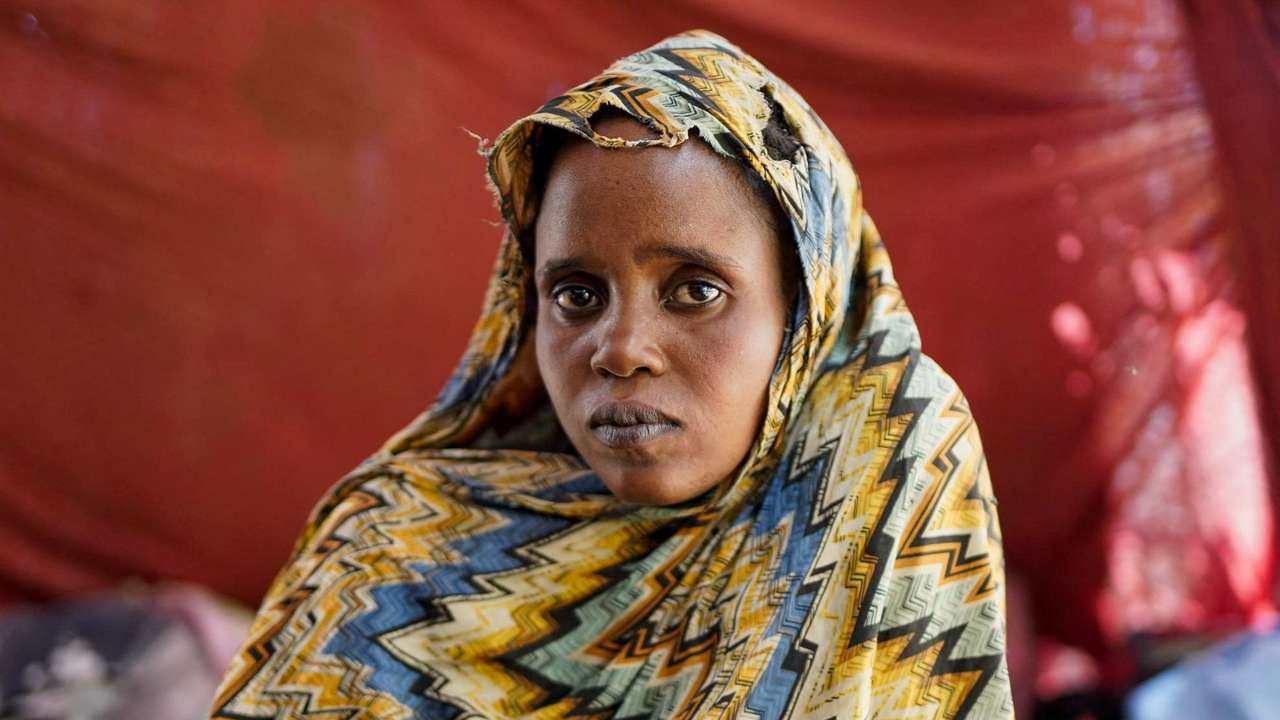 Israa Mukhtar, a witness of the RSF attack on Relief International's medical clinic, stands outside of a tent in Tawila