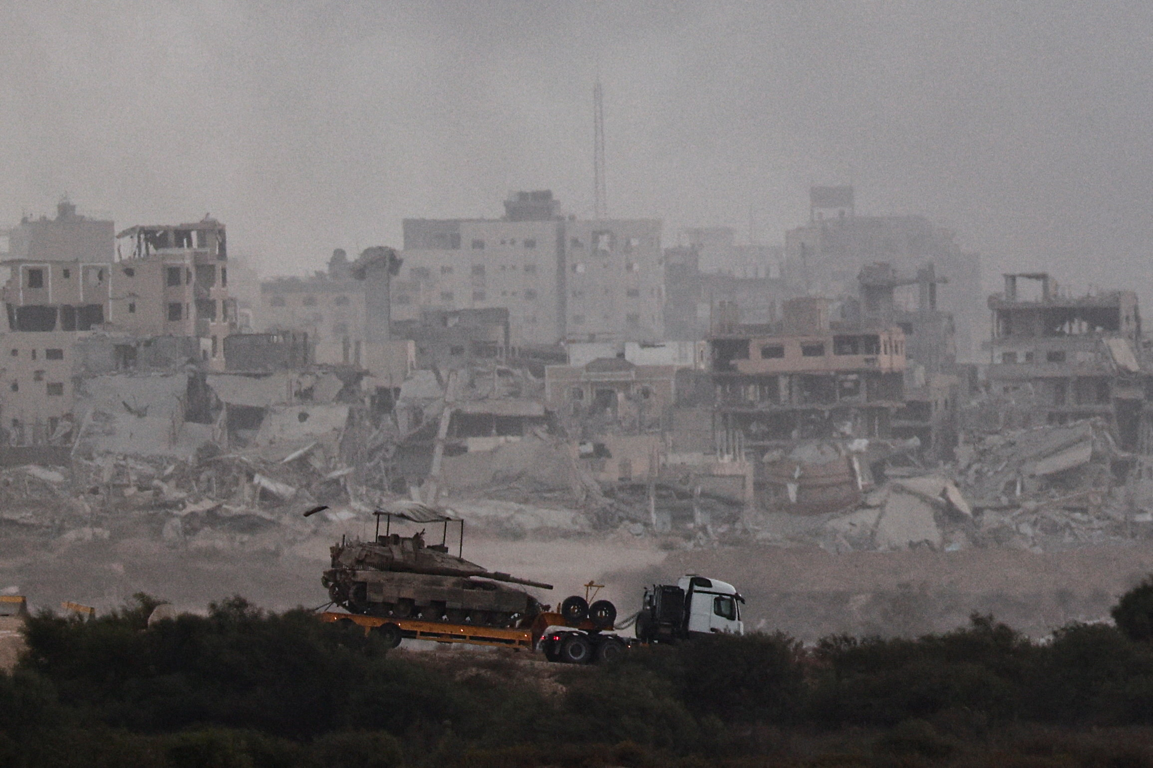 Truck transports a tank as it moves on the Israeli side of the border with Gaza