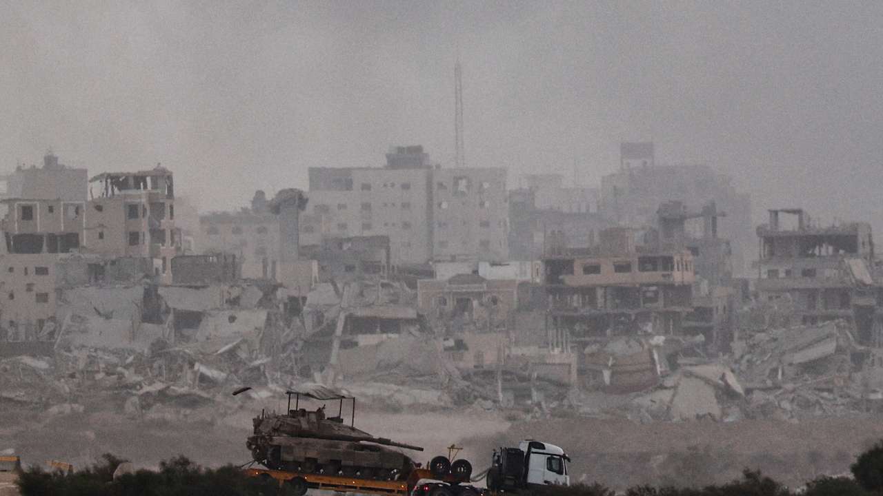 Truck transports a tank as it moves on the Israeli side of the border with Gaza
