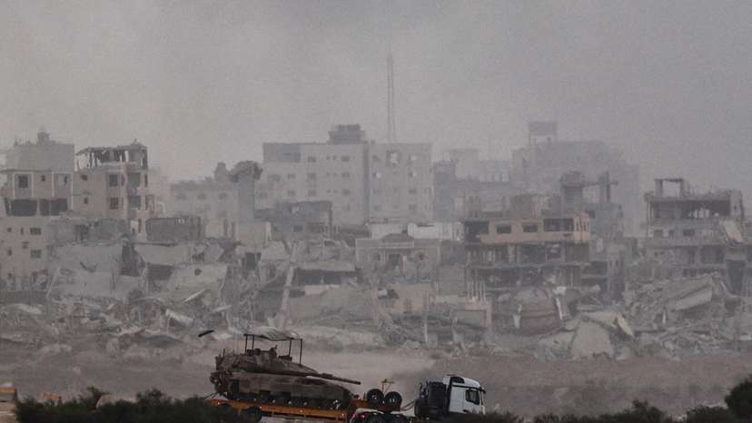 Truck transports a tank as it moves on the Israeli side of the border with Gaza