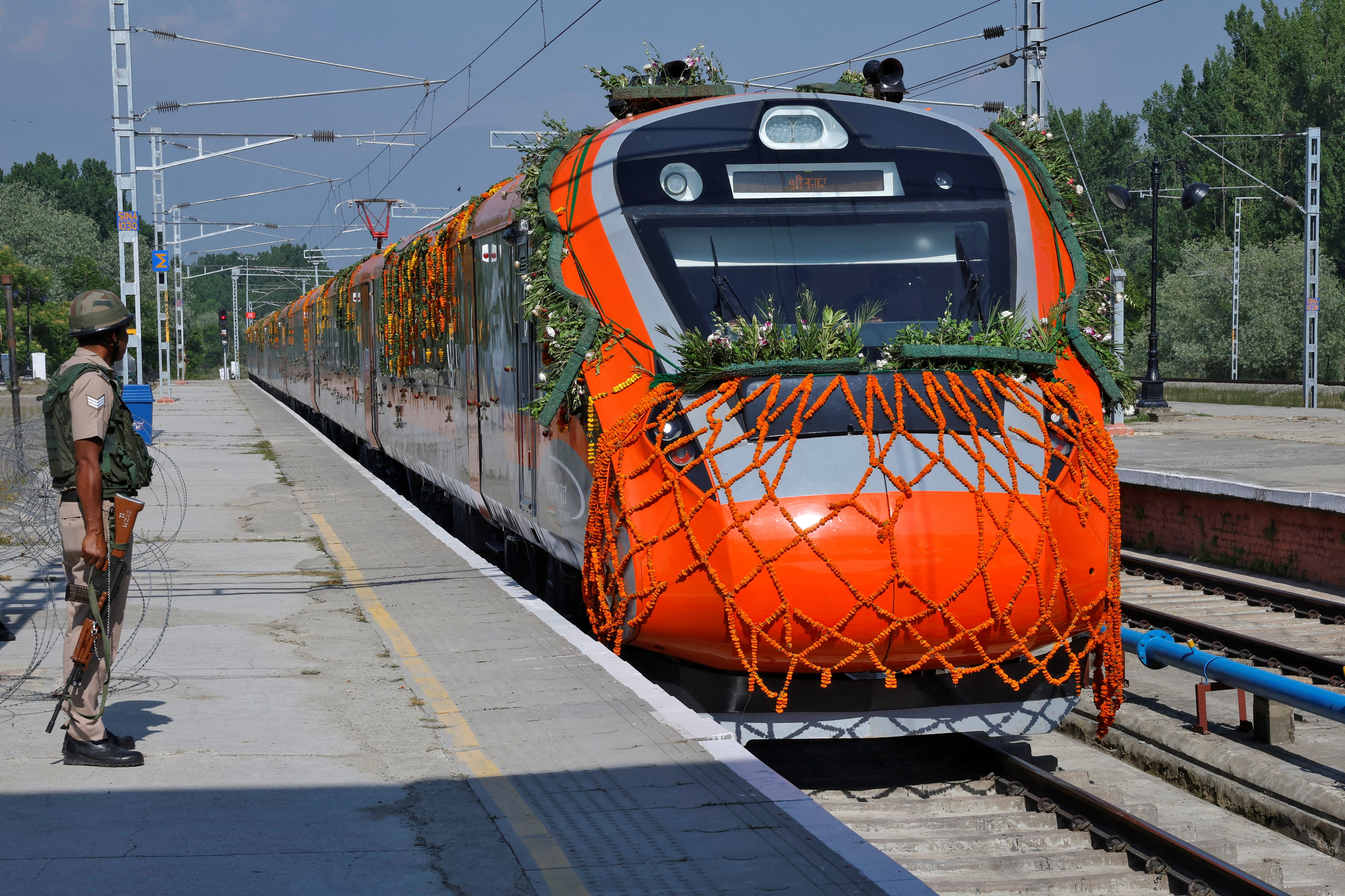 A security force personnel stands guard as India's high-speed train "Vande Bharat Express" arrives at Srinagar railway station