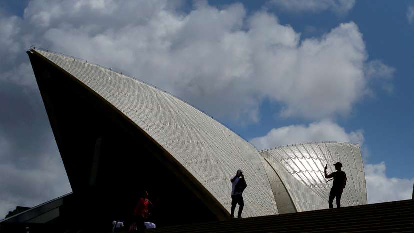 FILE PHOTO: Tourists take photographs with their mobile phones in front of the Sydney Opera House in Sydney