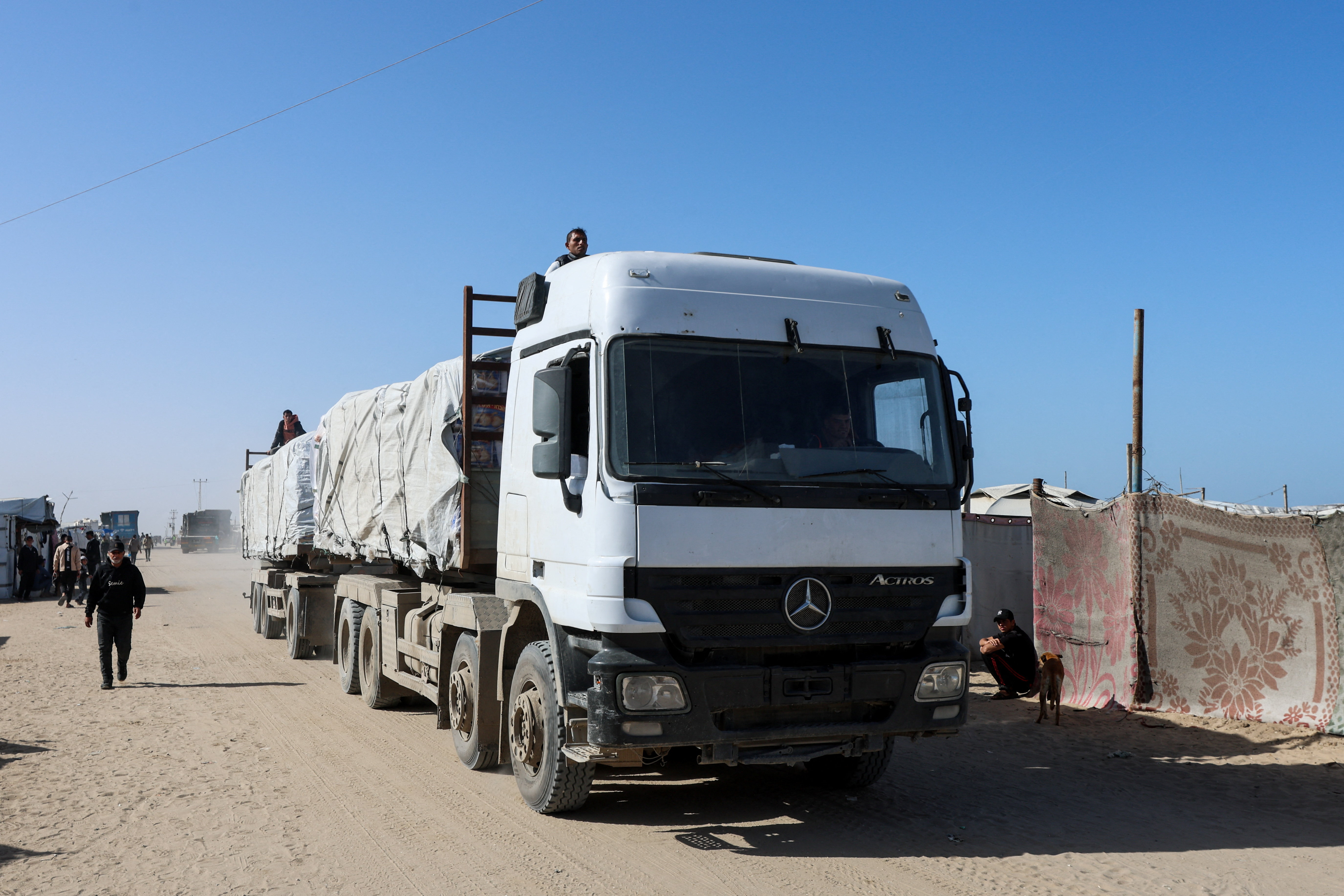 Aid trucks move on a road after entering Gaza through the Kerem Shalom crossing, in Rafah