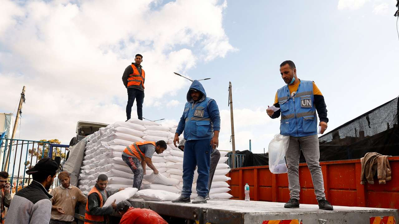 Palestinians receive flour bags distributed by UNRWA in Rafah
