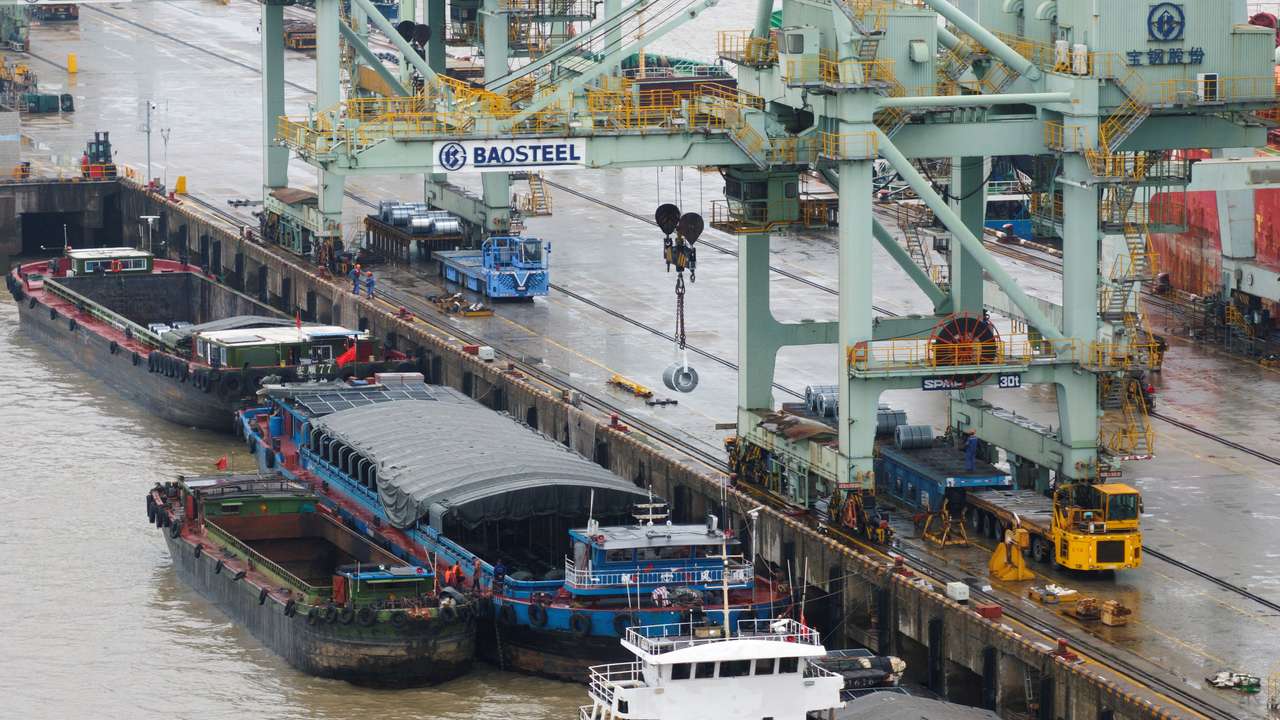 Crane transports steel coil at a port in Shanghai