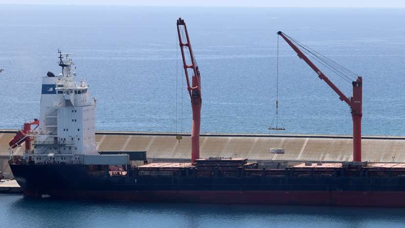 A crane lifts material onto a cargo vessel expected to take aid to Gaza from Cyprus, at the port of Larnaca