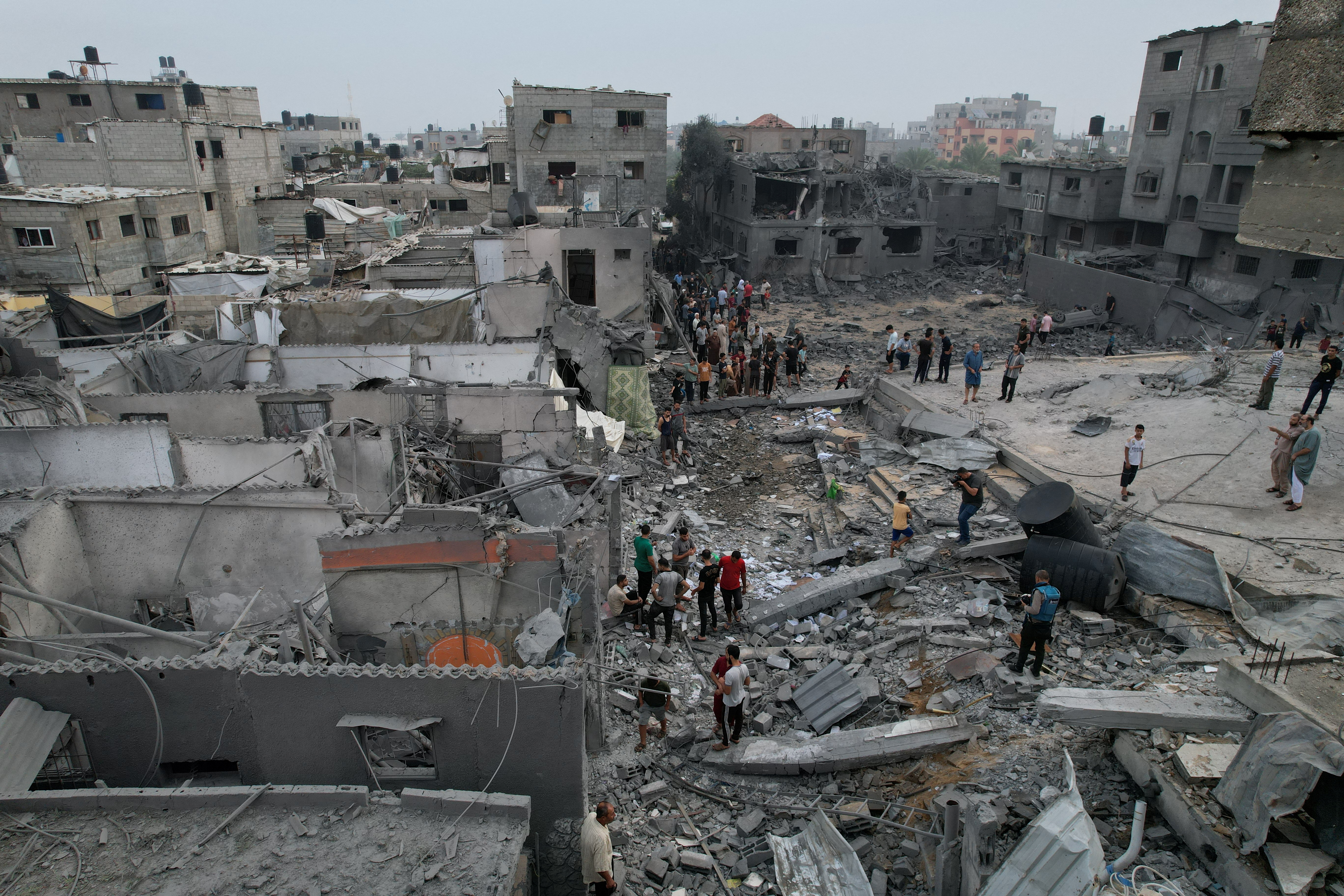 Palestinians gather at the site of Israeli strikes on houses and a mosque in the central Gaza Strip