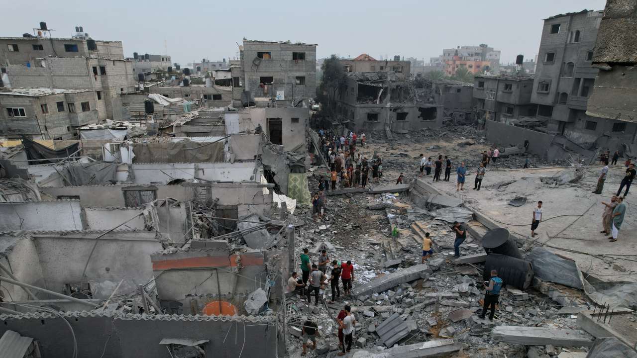 Palestinians gather at the site of Israeli strikes on houses and a mosque in the central Gaza Strip