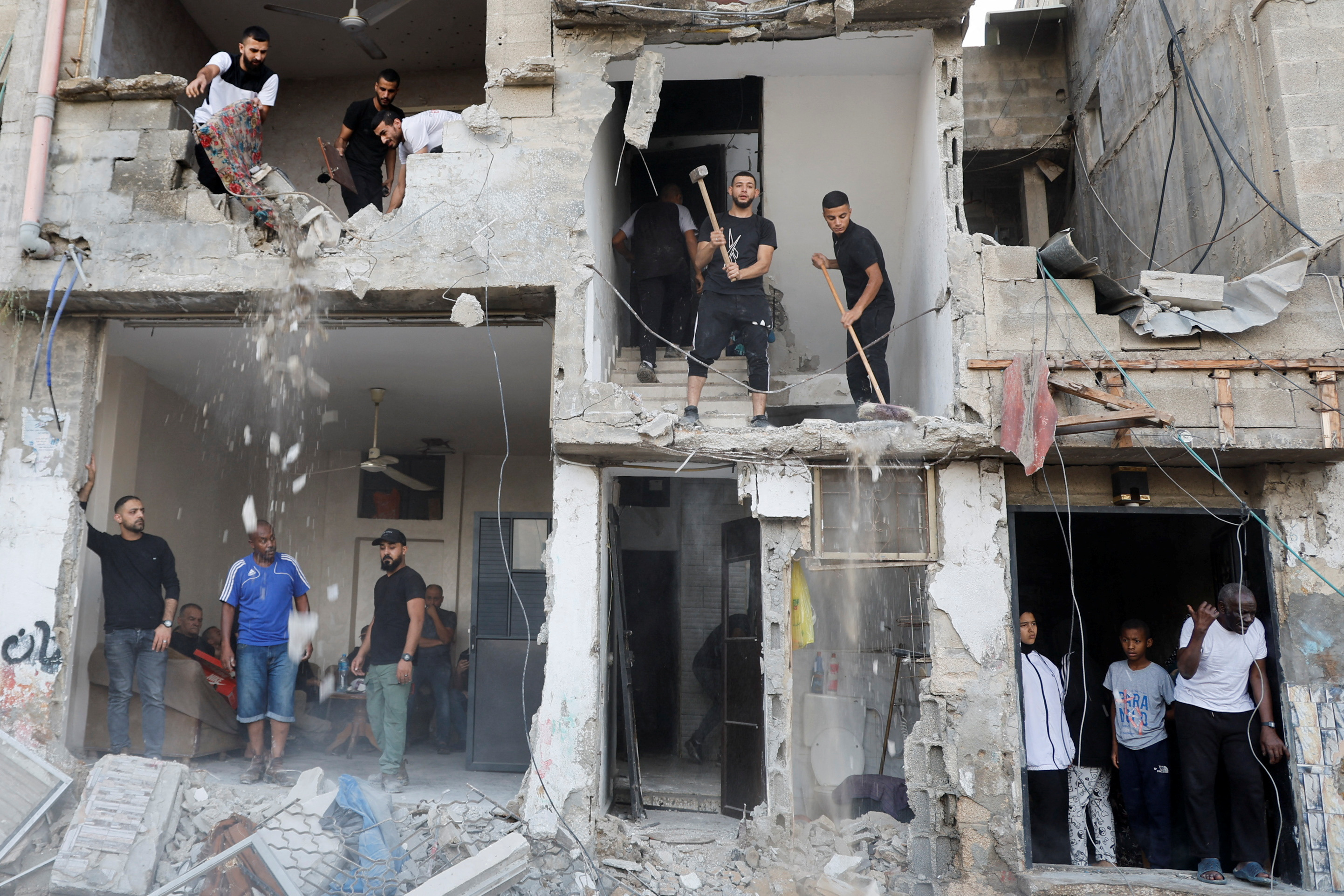 People inspect the damage following an Israeli military operation, in Tulkarm