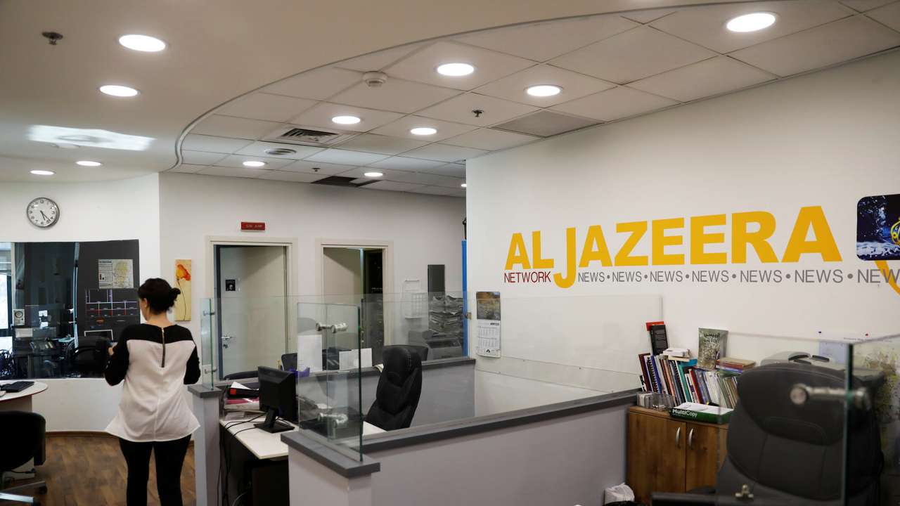 FILE PHOTO: An employee walks inside an office of Qatar-based Al-Jazeera network in Jerusalem