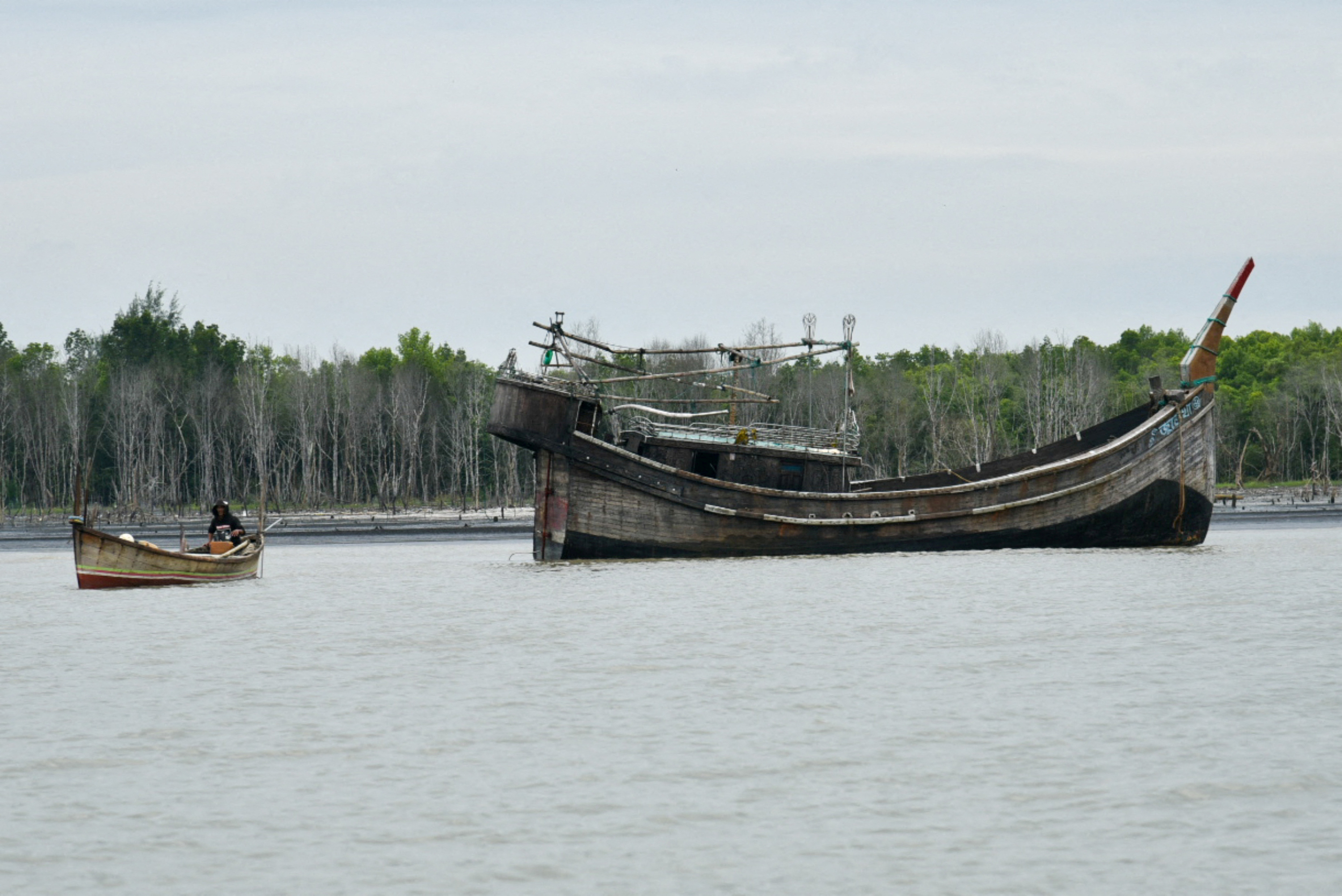 FILE PHOTO: A wooden boat that carried Rohingya Muslims floats off the coast of Karang Gading village
