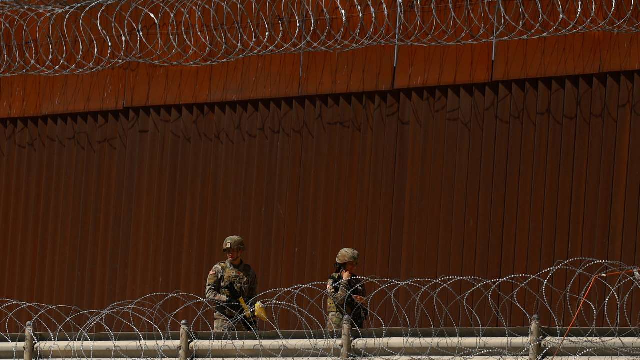 Texas National Guard soldiers walk near the U.S.-Mexico border wall, in Ciudad Juarez