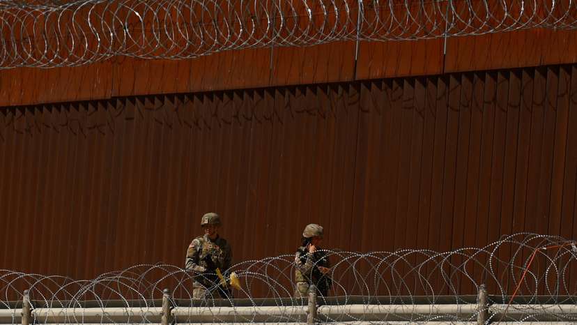 Texas National Guard soldiers walk near the U.S.-Mexico border wall, in Ciudad Juarez