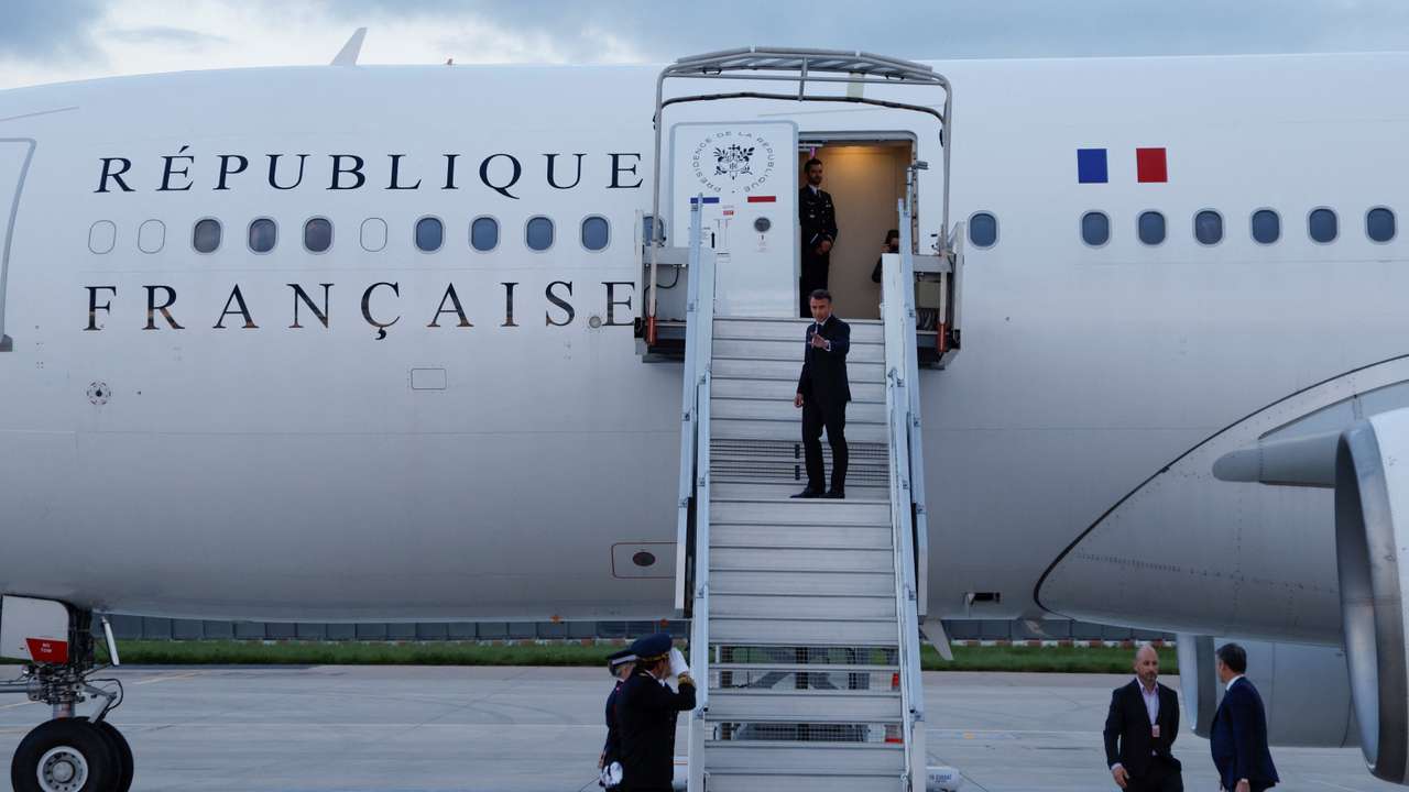 France's President Emmanuel Macron waves as he boards his Presidential plane to travel to the Pacific archipelago of New Caledonia