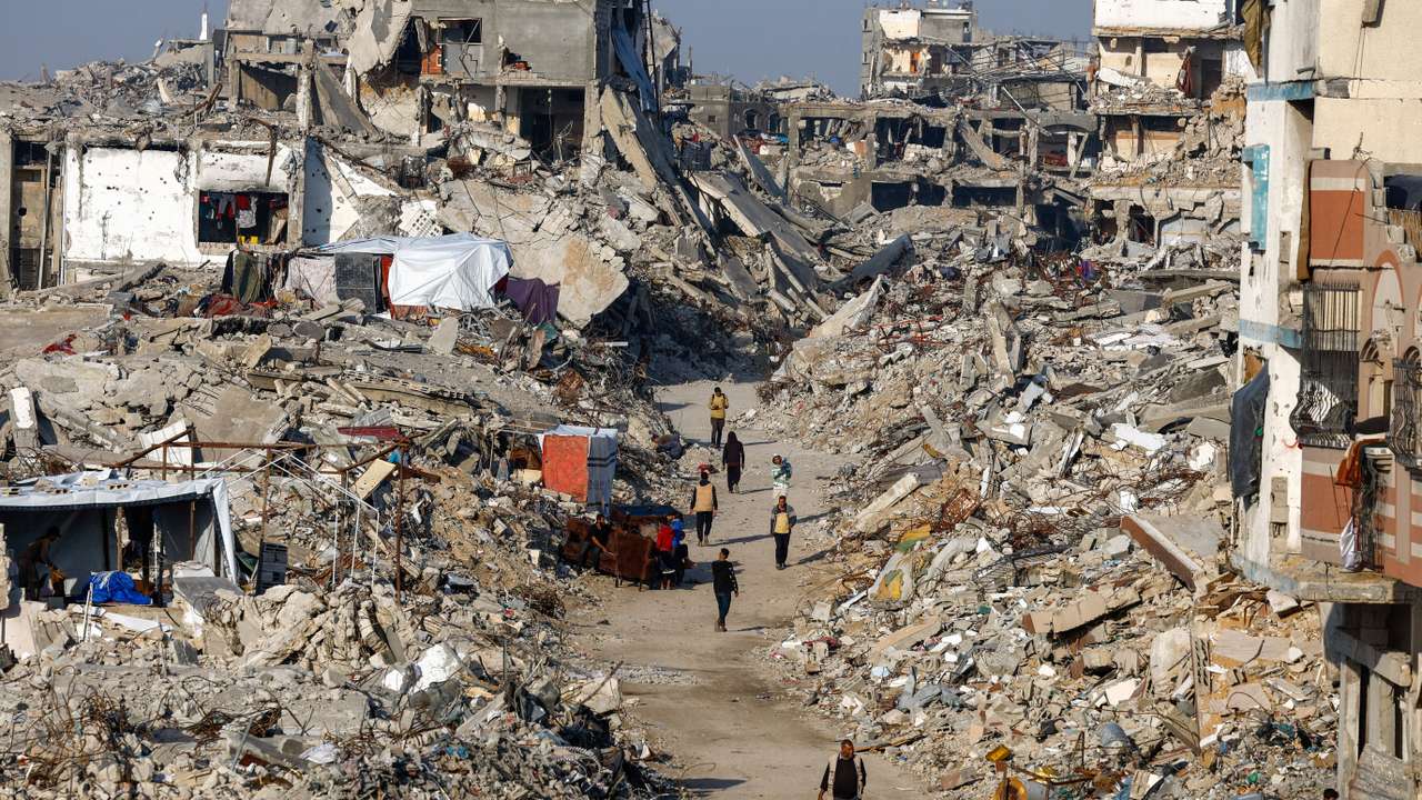 Palestinians walk among piles of rubble, amid a ceasefire between Israel and Hamas, in the northern Gaza Strip