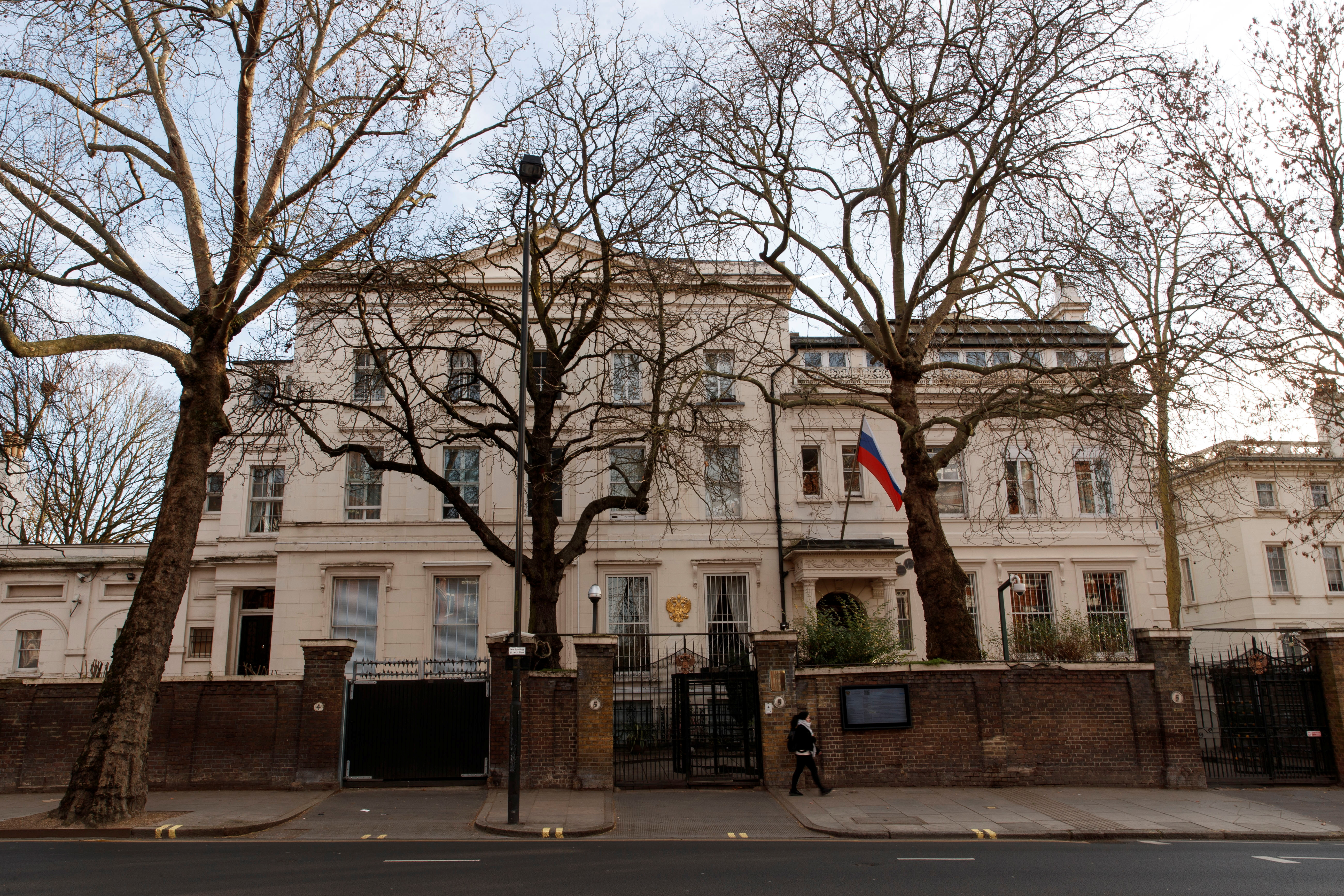 People walk in front of Russian Embassy in London