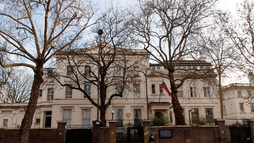 People walk in front of Russian Embassy in London
